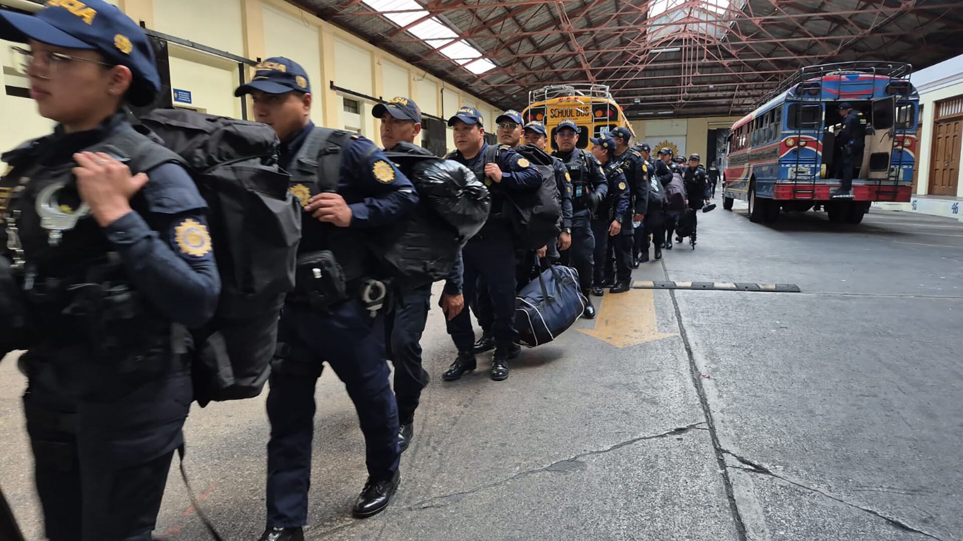 Agentes de la PNC de Guatemala se despliegan hacia destinos turísticos, equipados y dirigiéndose a autobuses para fortalecer la seguridad en la región. (PNC de Guatemala)
