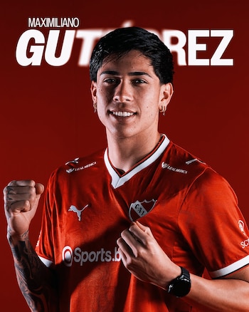 Maximiliano Gutiérrez sonríe luciendo una camiseta roja deportiva con la mano en el escudo sobre un fondo rojo con su nombre