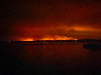 Una vista muestra la luz y el humo de los incendios forestales en Mallacoota, Victoria, Australia, el 31 de diciembre de 2019 (George Mills/Social Media via REUTERS)