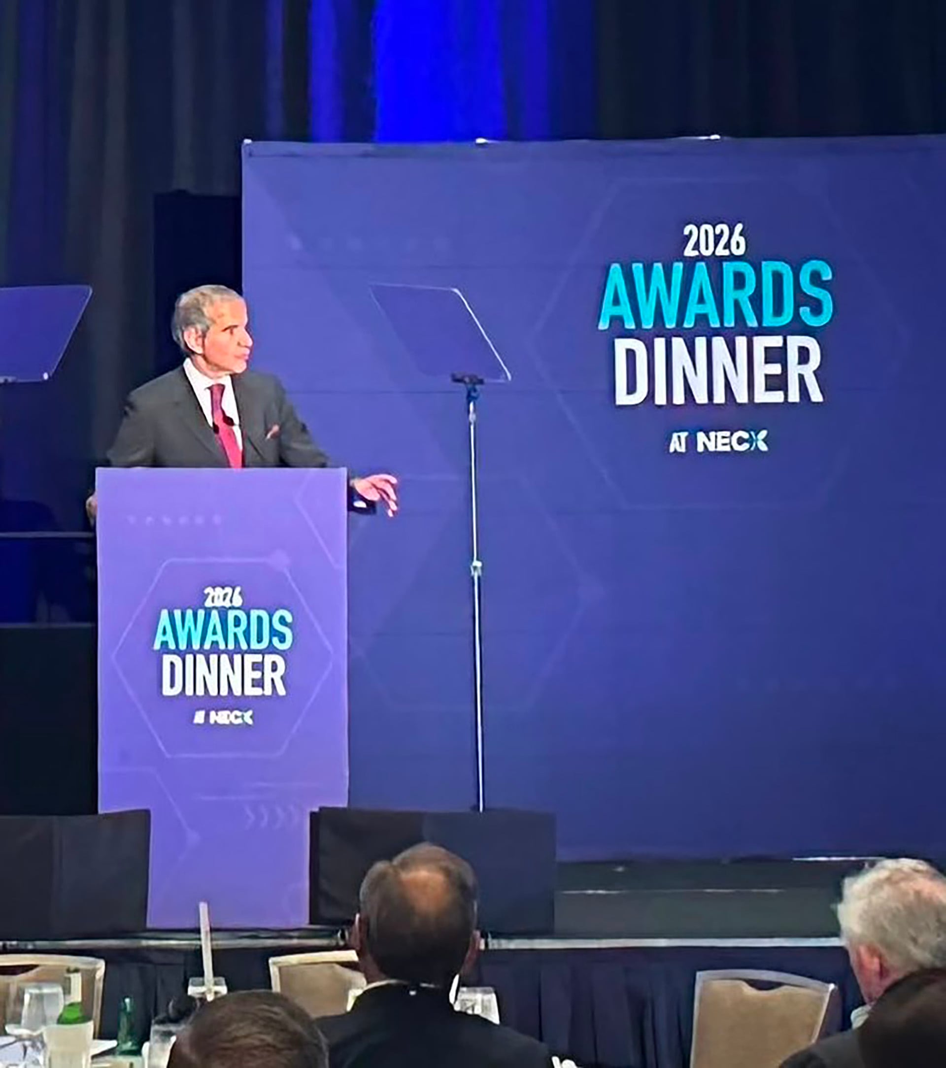 Rafael Grossi dirige unas palabras al público desde un podio durante la cena de premios del evento de NECX