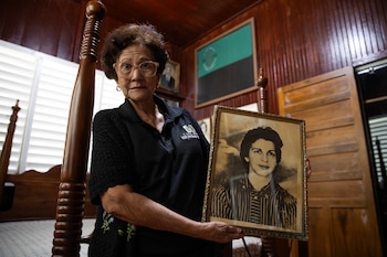 (REPÚBLICA DOMINICANA), 12/03/2026.- Emelda Ramos, encargada de la biblioteca del Museo Hermanas Mirabal, posa con el último retrato de la abogada y activista Minerva Mirabal en Salcedo. "Si me mata, yo sacaré mis brazos de la tumba y seré más fuerte", repetía la joven abogada, activista y política dominicana Minerva Mirabal, que desafió al sanguinario dictador Rafael Trujillo (1930-1961) y de cuyo nacimiento se conmemora este jueves un siglo, convertida, junto a sus hermanas Patria y María Teresa, en un símbolo de la lucha de las mujeres en el mundo. EFE/ Orlando Barría