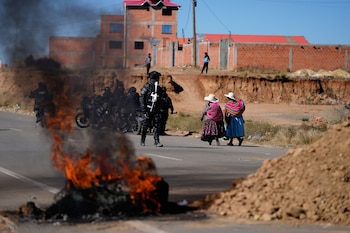 Presencia policial y barricadas en una carretera bloqueada por manifestantes antigubernamentales en El Alto, Bolivia (AP/Juan Karita)