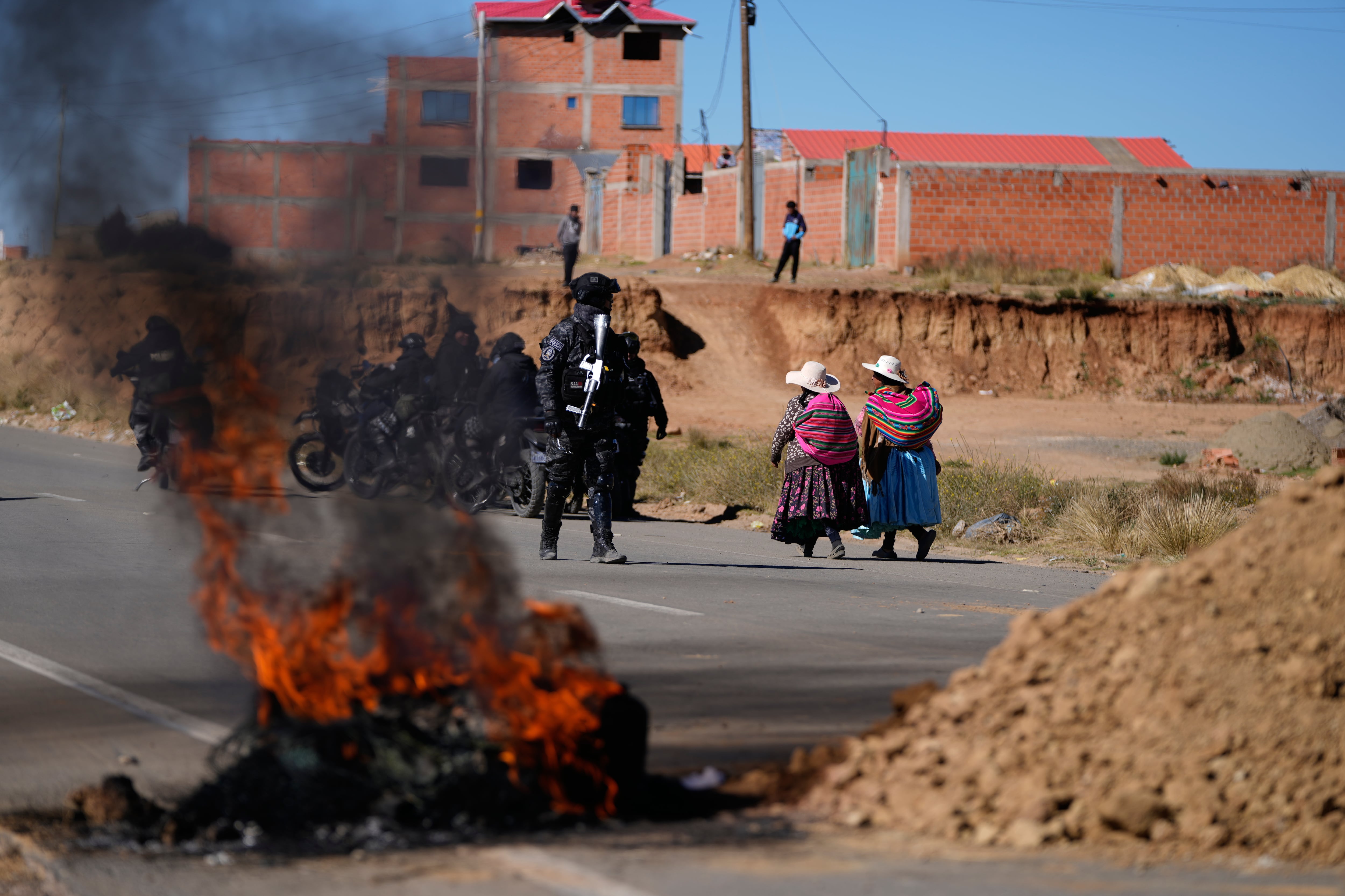 Presencia policial y barricadas en una carretera bloqueada por manifestantes antigubernamentales en El Alto, Bolivia (AP/Juan Karita)