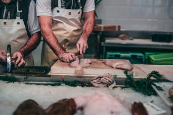 Un pescadero preparando un pescado (Unsplash)