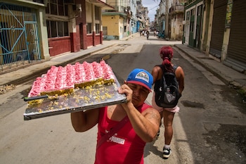 Un vendedor ambulante de pasteles camina por el centro de la calle en busca de clientes en La Habana, Cuba (Foto AP/Ramón Espinosa)