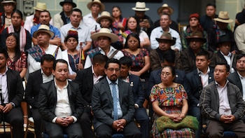 Un grupo de funcionarios y autoridades indígenas posan frente a una pantalla azul durante un acto oficial en Guatemala