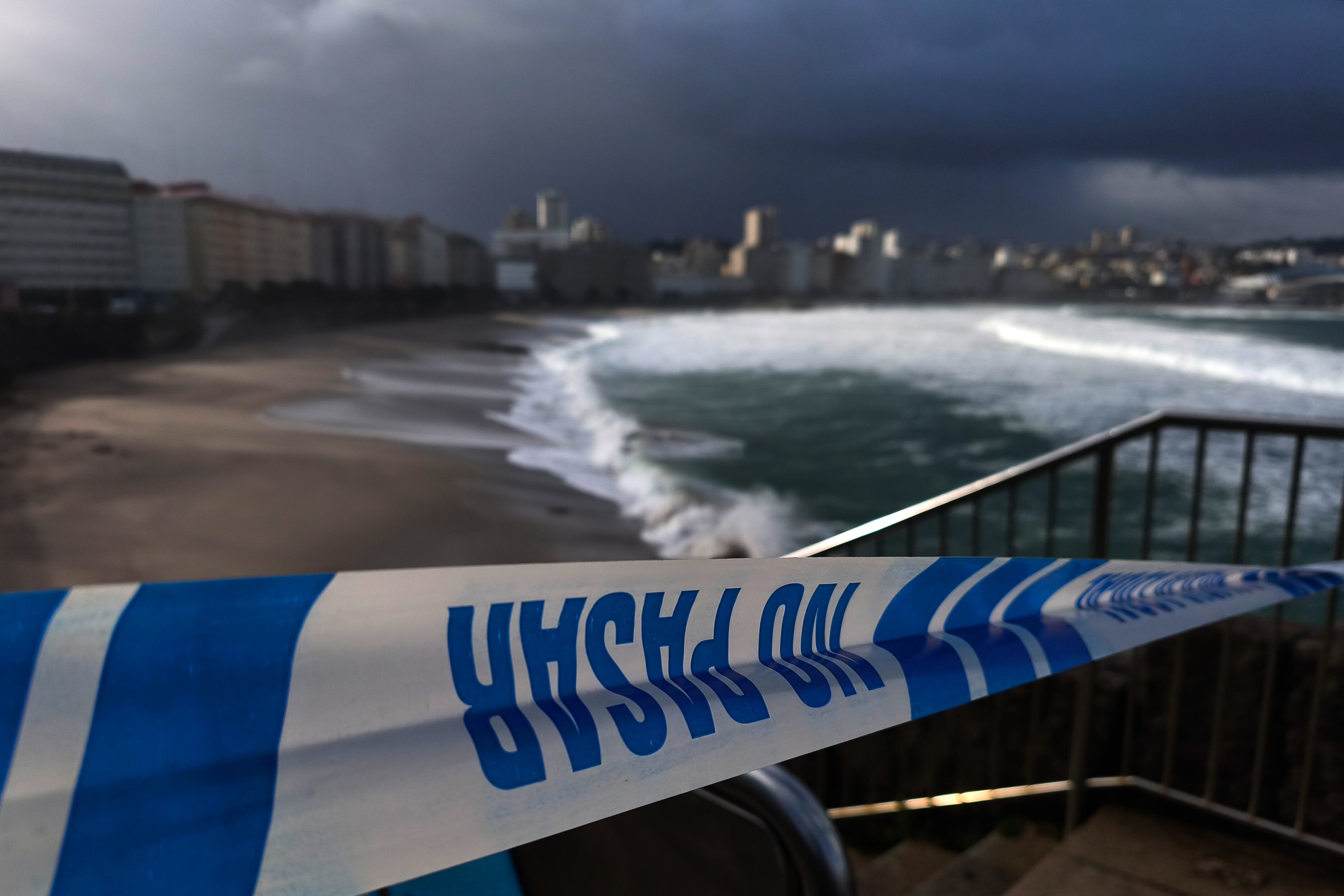 Una cinta policial impedía este miércoles el acceso a la playa del Orzán, en A Coruña, este miércoles a causa de la nueva borrasca, Kristin, que mantiene en alerta por nieve, lluvia y viento a todas las comunidades autónomas, salvo a Navarra. (Cabalar/EFE)