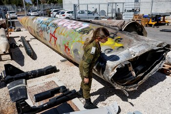 Una soldado israelí junto a los restos de un misil balístico iraní Emad en la base militar de Julis. (REUTERS/Amir Cohen)