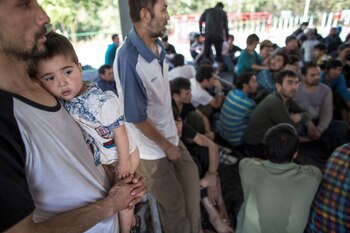 FOTO DE ARCHIVO: Un presunto uigur de la región occidental china de Xinjiang, sostiene a su hijo en un refugio temporal después de que fueron detenidos en la sede regional de inmigración cerca de la frontera entre Tailandia y Malasia en Hat Yai, Songkla, el 14 de marzo de 2014. (REUTERS / Athit Perawongmetha)