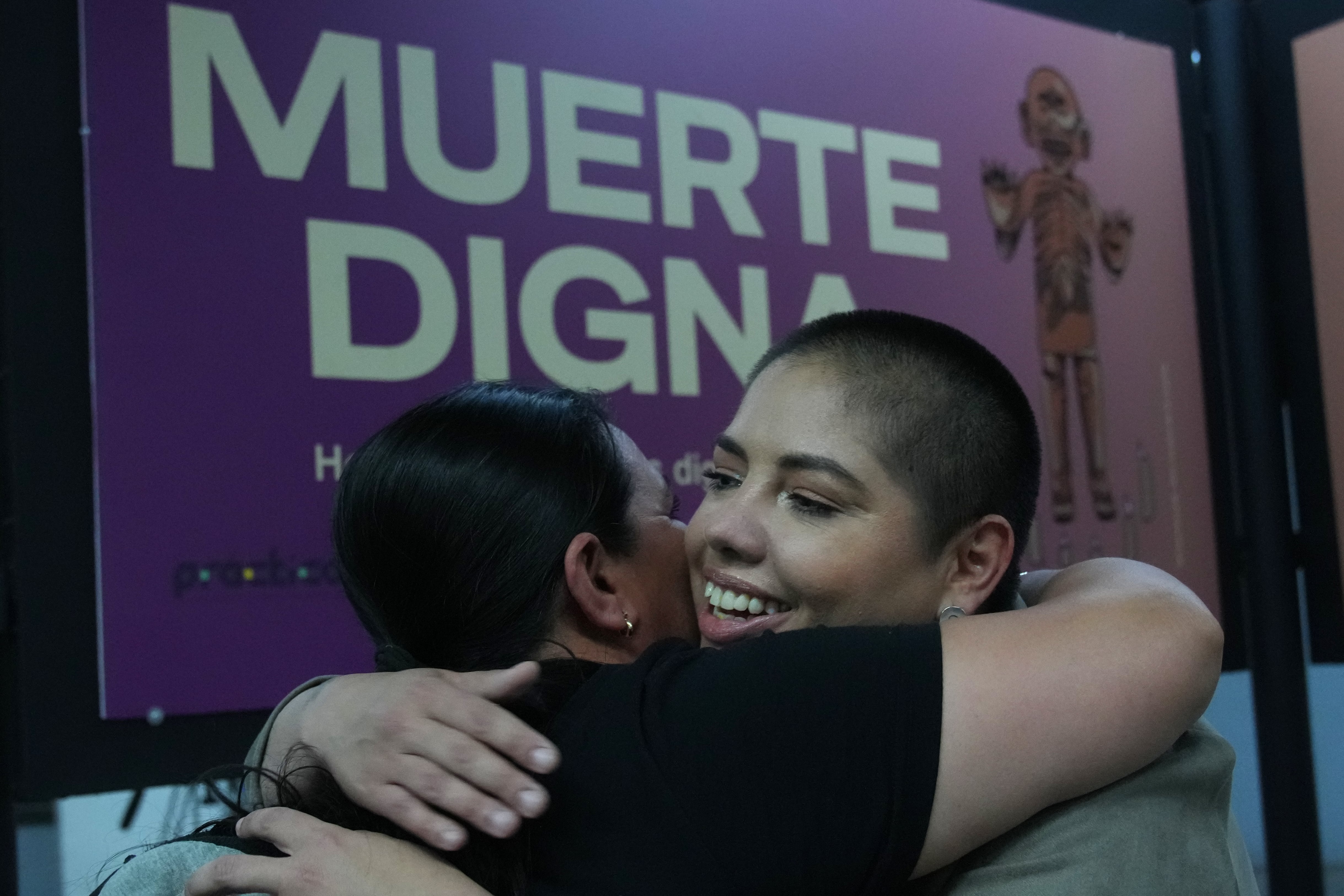 Samara Martínez, defensora de una ley para despenalizar la eutanasia, abraza a una amiga durante la exposición