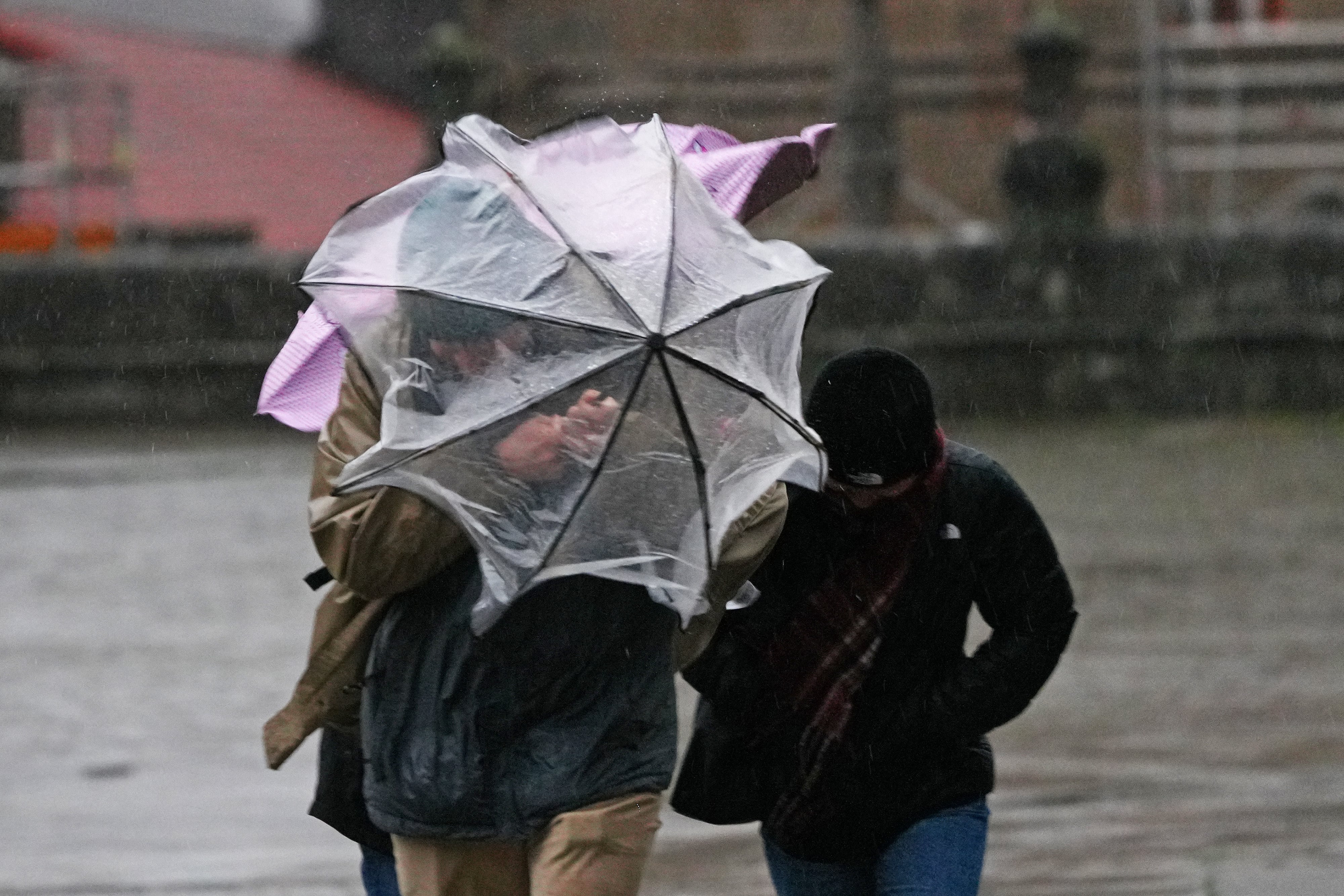 Varias personas intentan sujetar sus paraguas, a 26 de enero de 2026, en Santiago de Compostela. (Álvaro Ballesteros / Europa Press)