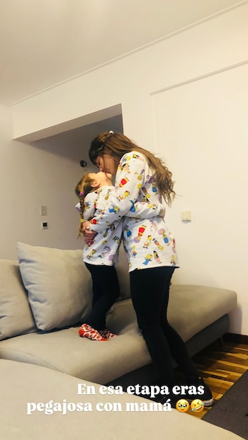 Valeria Aquino y su hija Alma se abrazan y besan. Ambas visten camisetas con estampados de Los Simpson. La niña está sobre un sofá claro