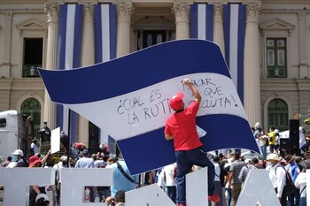 Un manifestante escribe sobre una