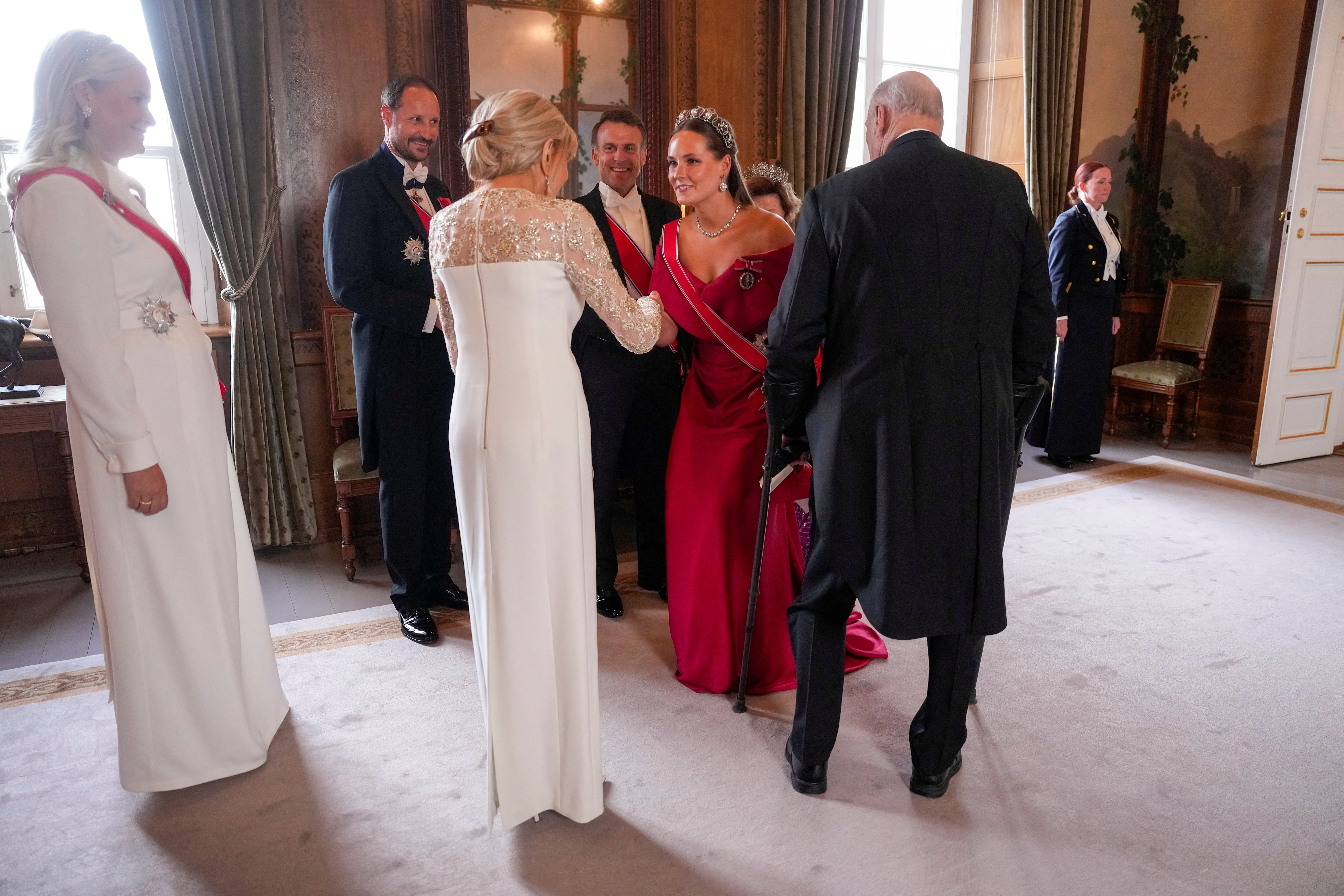 El rey Harald de Noruega, la reina Sonja, el príncipe heredero Haakon, la princesa heredera Mette-Marit y la princesa Ingrid Alexandra dan la bienvenida al presidente francés Emmanuel Macron y a su esposa Brigitte Macron en la Sala de los Pájaros del Palacio Real de Oslo. (Javad Parsa/REUTERS)