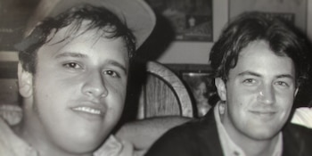 Fotografía en blanco y negro de dos hombres jóvenes en plano medio corto dentro de un espacio interior