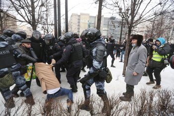 Riot police detain a supporter
