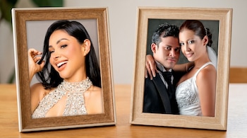 Dos portarretratos de madera clara sobre una mesa. A la izquierda, Pamela Franco sonríe. A la derecha, Christian Domínguez y Karla Tarazona en foto de boda.