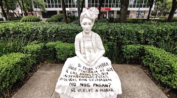 Una estatua que representa a Frida Kahlo lleva un mensaje escrito en su falda sobre la falta de pago a los artistas desde Cultura, sobre Paseo de la Reforma