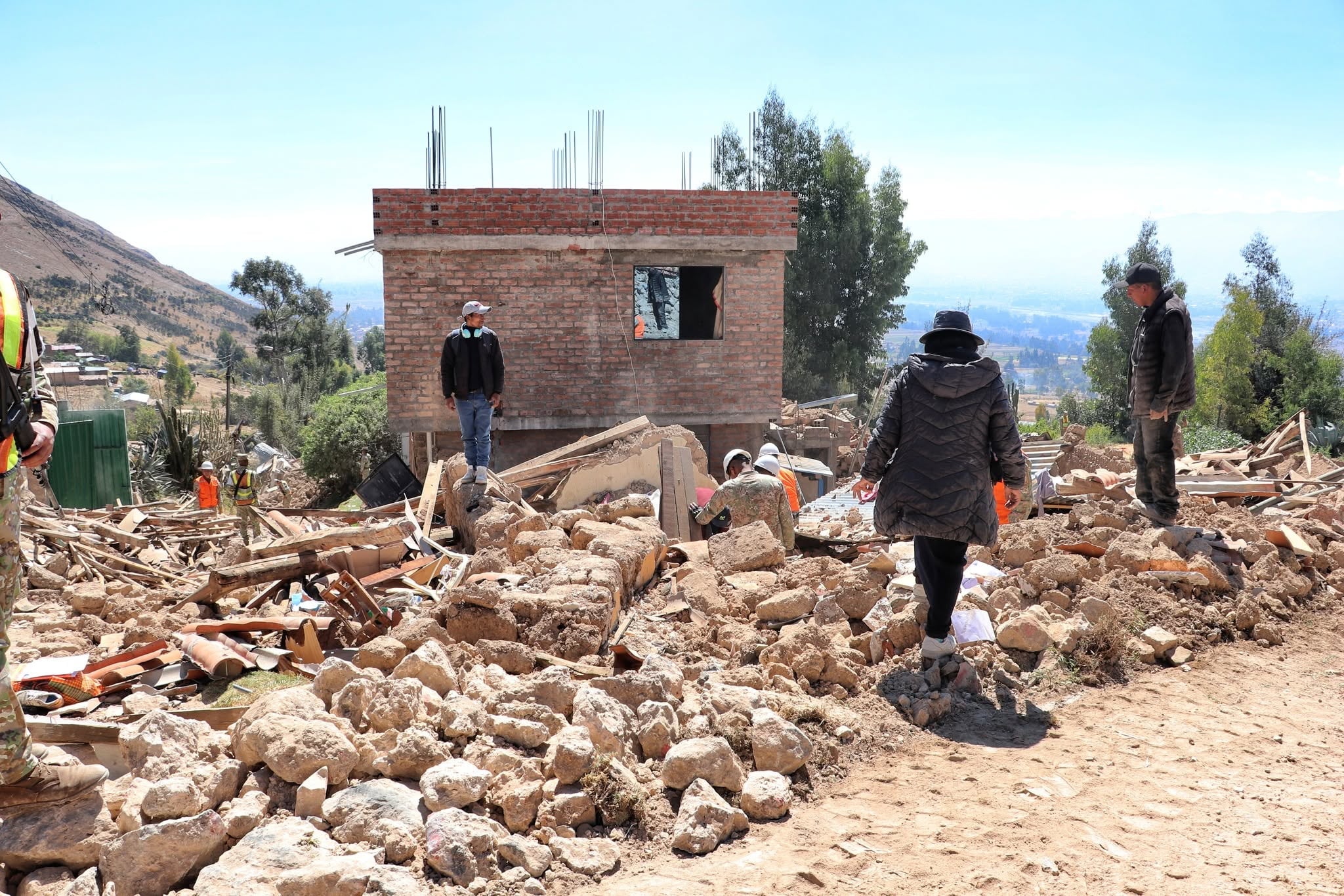 Pobladores y personal de asistencia transitan entre los escombros de viviendas destruidas en Pumpunya, Chongos Bajo, Junín, tras el sismo de 5.1. (Gobierno Regional de Junín)