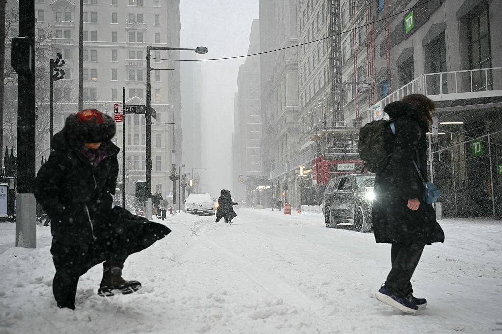 Peatones caminan por una calle de Manhattan cubierta de nieve durante una tormenta invernal que llevó a las autoridades a reforzar las medidas de protección frente al riesgo de hipotermia.