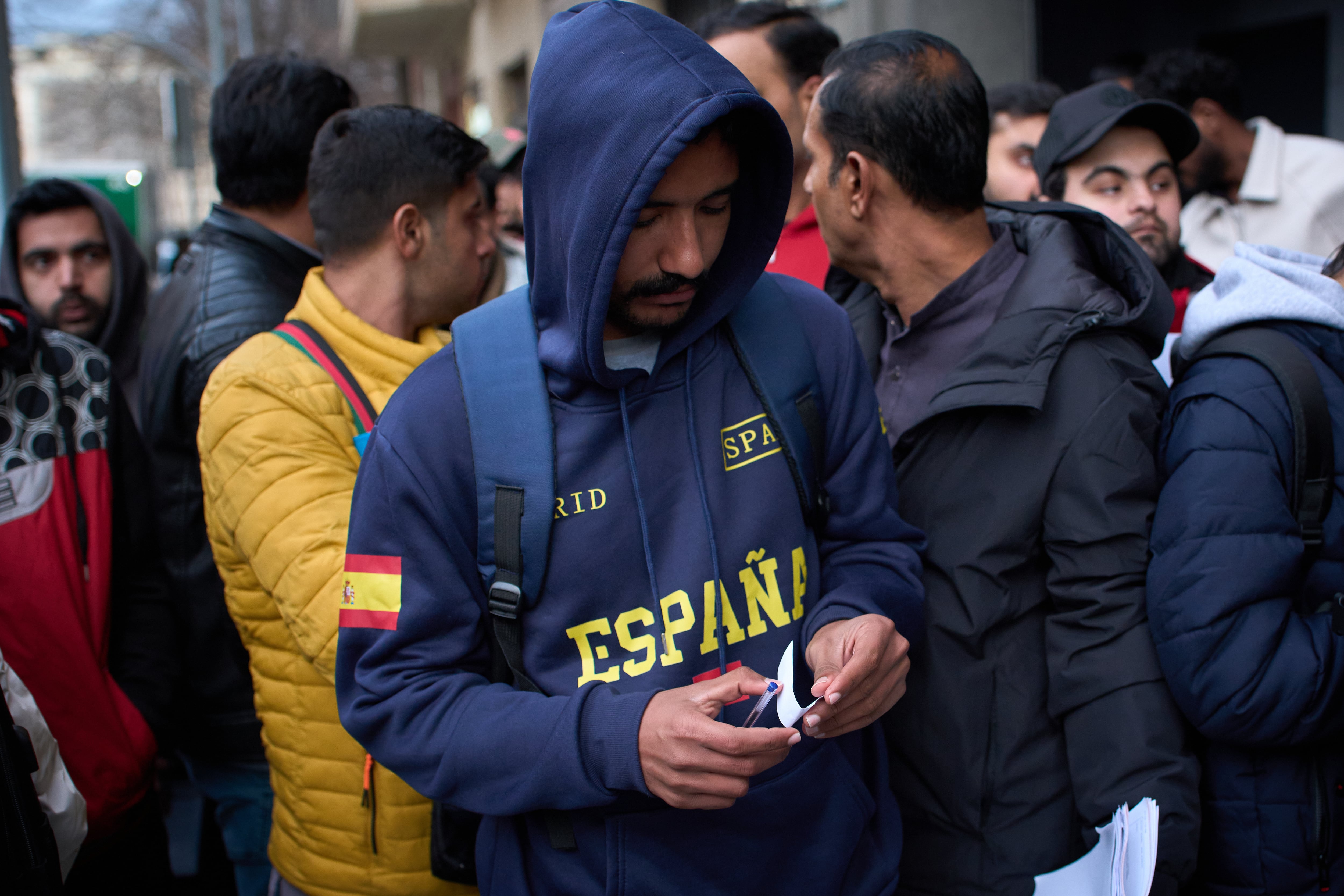 Paquistaníes se reúnen en la entrada del consulado en Barcelona tras la decisión del Gobierno de conceder permisos de residencia y trabajo. (Foto AP/Emilio Morenatti)