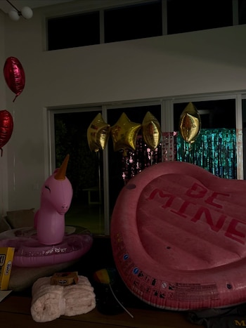 Globos rojos y dorados, un unicornio inflable y un flotador con la leyenda "Be Mine": así lucía el espacio antes de que comenzara la celebración