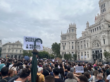 Una multitud de personas en la calle sostiene carteles con la frase Derecho a techo frente al edificio del Palacio de Cibeles