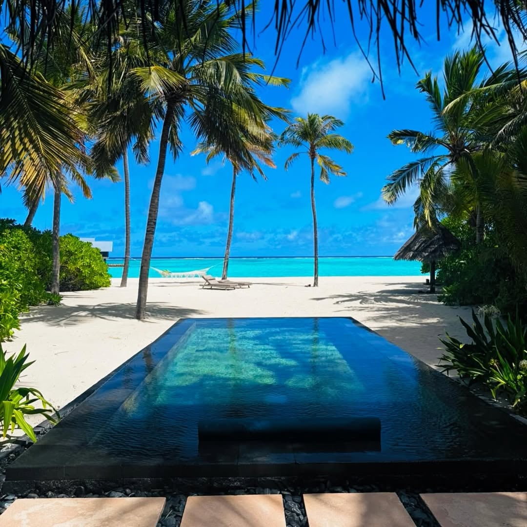 Otra piscina rectangular, enmarcada por palmeras, brindó vista directa a la playa y al mar