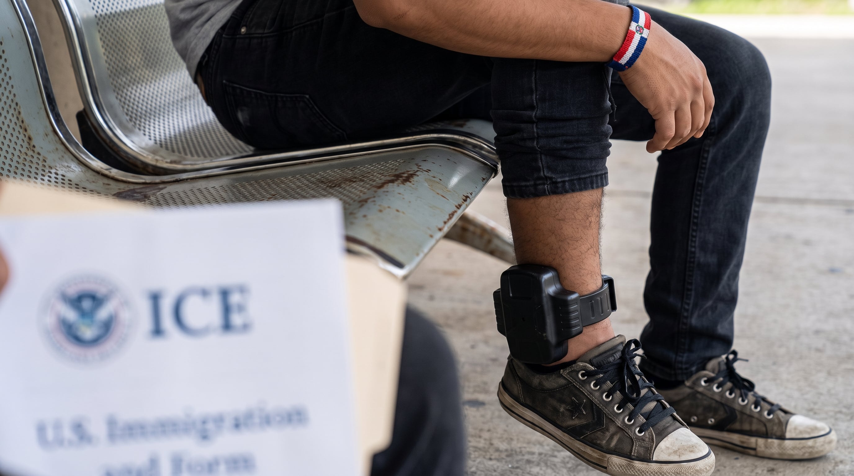 Un joven dominicano, bajo monitoreo electrónico de ICE, sostiene un documento oficial con el logo de la agencia. (Imagen Ilustrativa Infobae)