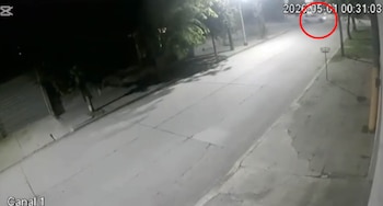Vista aérea de cámara de seguridad nocturna en Lobería. Se observa una calle iluminada por farolas y un coche en movimiento, resaltado por un círculo rojo
