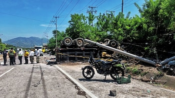 Las autoridades indicaron de forma preliminar que la volqueta presentó un desperfecto mecánico antes de salir de la carretera, impactar un poste y volcar. (Foto cortesía PNC)