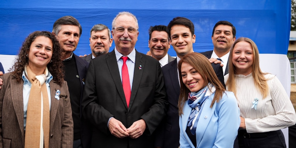 Hugo Passalacqua posa con dirigentes e intendentes frente a una bandera argentina
