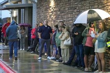 Votantes bajo la lluvia durante el día de las elecciones de Estados Unidos en el centro comunitario Richard y Meg Weekley en Cypress, Texas. (Brett Coomer/Houston Chronicle via AP)