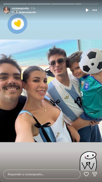 Cuatro personas sonriendo: mujer, hombre con bigote, hombre con camiseta argentina y gafas, niño con camiseta verde y pelota. Fondo con mar y playa