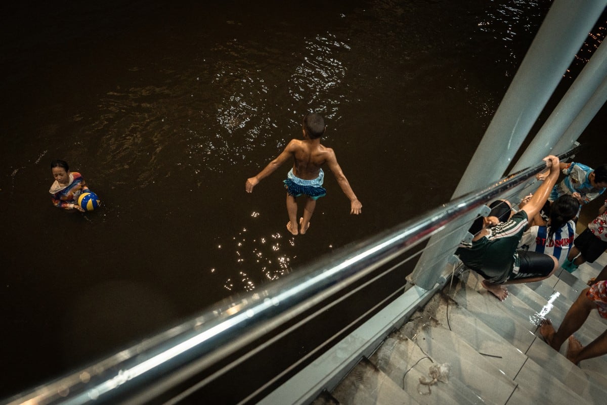 Niños juegan en el agua de la inundación en el distrito de Bang Kapi, Bangkok. Una vecina de 55 años dijo que las inundaciones son