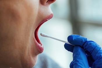 Un sanitario toma una muestra de saliva (Magnific)