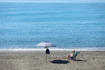 Un hombre disfruta del buen tiempo en la playa de las Gaviotas en Torre de Benegalbón, Málaga, a 19 de abril de 2026. (EFE/ Jorge Zapata)