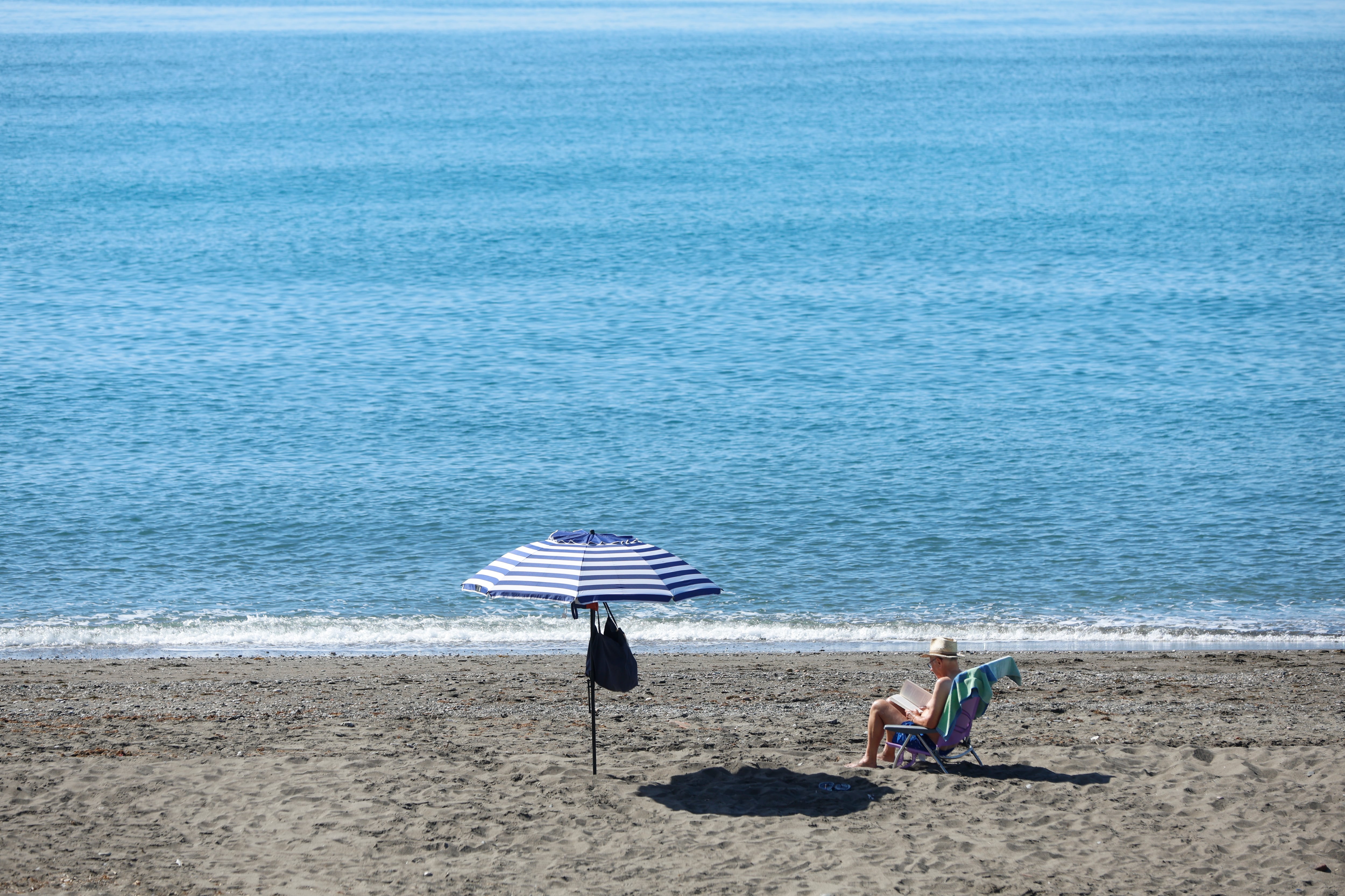 Un hombre disfruta del buen tiempo en la playa de las Gaviotas en Torre de Benegalbón, Málaga, a 19 de abril de 2026. (EFE/ Jorge Zapata)