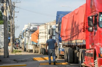 Vehículos hacen largas horas de fila para cargar combustible. (Photo by RODRIGO URZAGASTI / AFP)