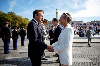 Macron, es recibido por la primera ministra Elisabeth Borne, mientras asiste al desfile militar anual del Día de la Bastilla (REUTERS/Sarah Meyssonnier)