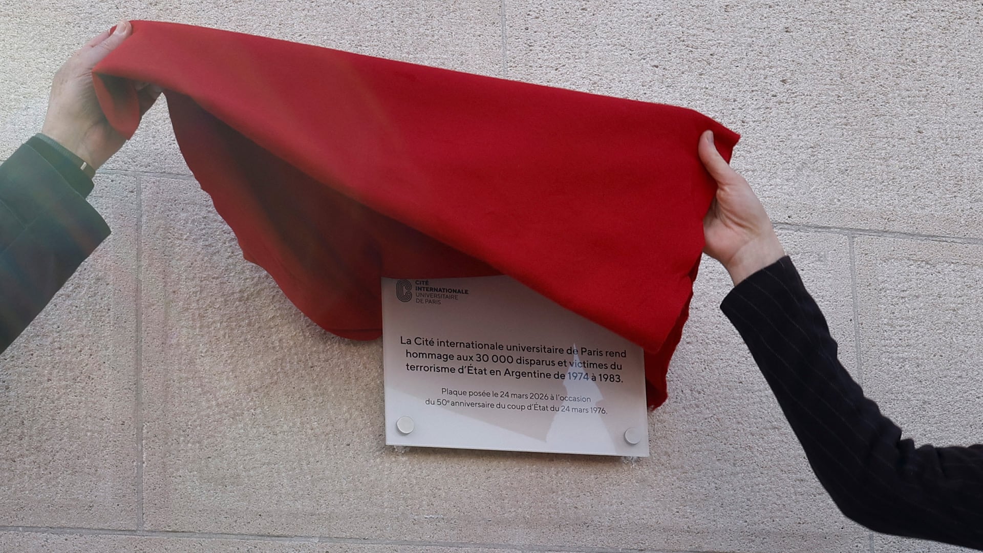 El momento en que se descubre la nueva placa, en un edificio cercano a la Casa argentina en París.