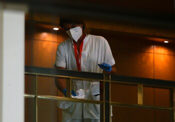 Una empleada limpia un pasamanos