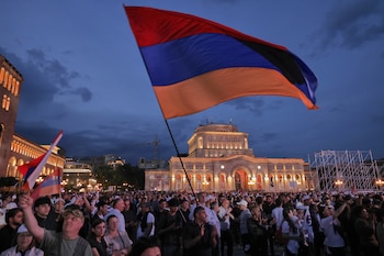 Partidarios del magnate ruso-armenio Samvel Karapetyan ondean una bandera nacional durante una protesta contra el primer ministro en funciones, Nikol Pashinyan, en la Plaza de la República de Ereván, Armenia, el miércoles 3 de junio de 2026. Karapetyan, líder del partido Armenia Fuerte, enfrenta cargos penales que él rechaza por considerarlos políticamente motivados y realiza campaña desde su arresto domiciliario (AP/Anthony Pizzoferrato)