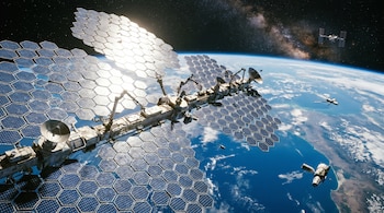 Gran estación espacial con paneles solares hexagonales reflejando la luz del sol, múltiples antenas, otros satélites, la Tierra y el espacio profundo.