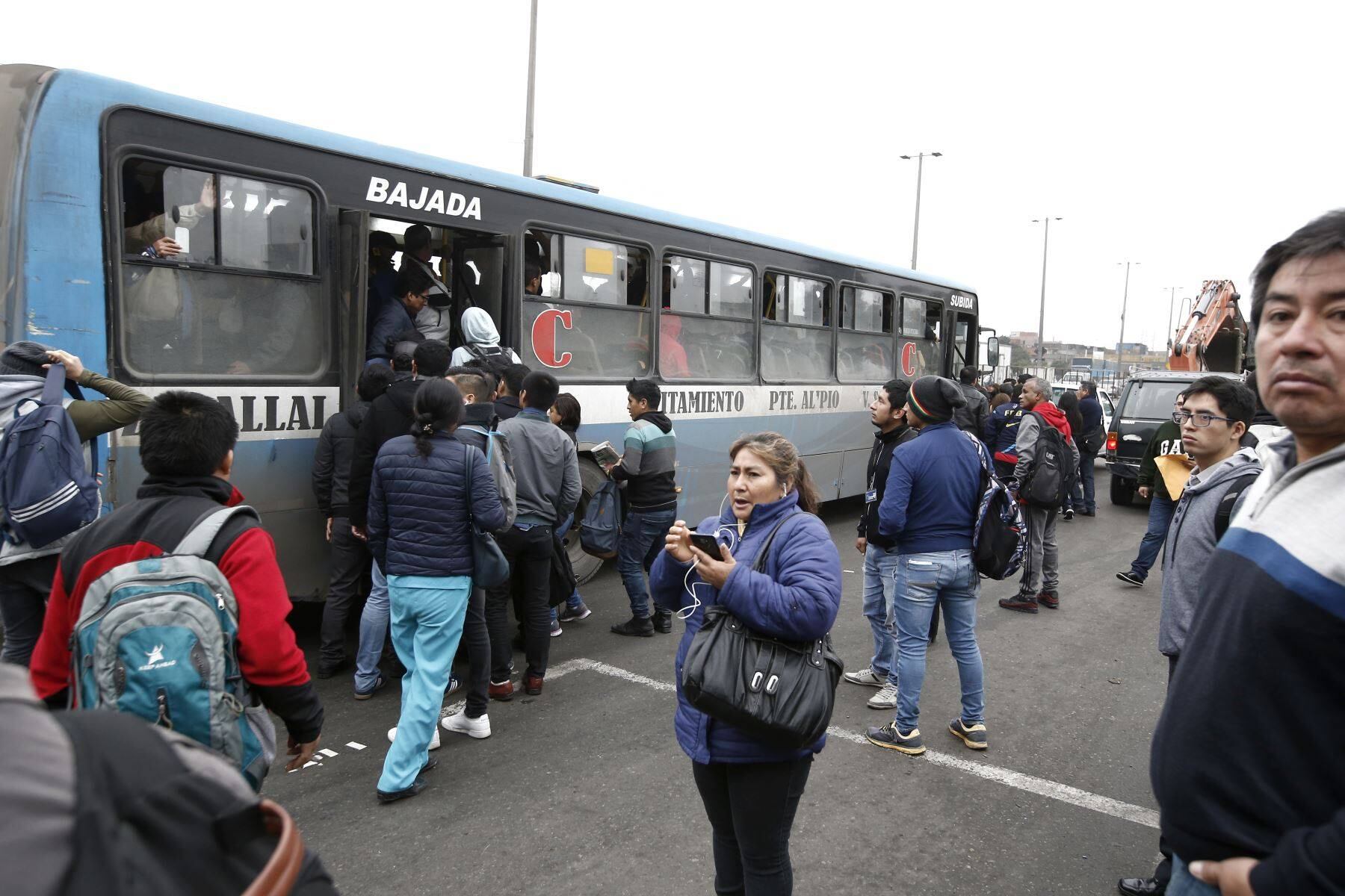 Un grupo de ciudadanos pugna por subir a uno de los buses conocidos como 'El Chino', en la Panamericana Norte, en un día de paro de transportistas. (Andina)