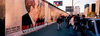 La gente se reúne en una pintura del ex líder soviético Leonid Brezhnev, a la izquierda, besando al ex líder de Alemania Oriental Erich Honecker en East Side Gallery