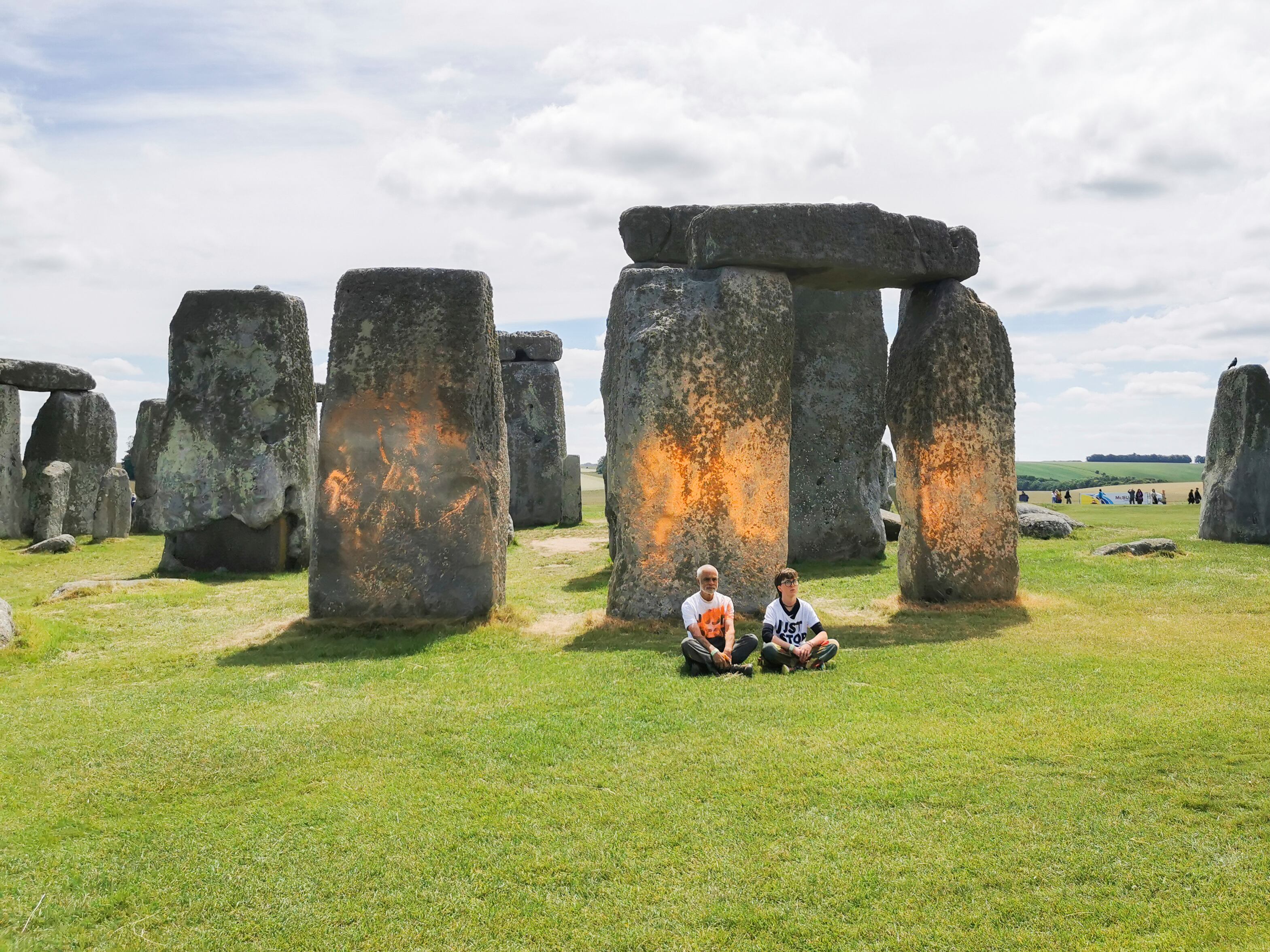 En esta fotografía se muestran unos manifestantes del grupo Just Stop Oil tras rociar pintura naranja en el monumento de Stonehenge, en Salisbury, Inglaterra, el miércoles 19 de junio de 2024. (Just Stop Oil vía AP)