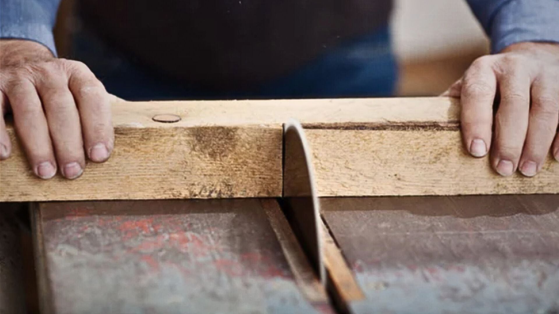 Un carpintero trabaja con madera en su taller.