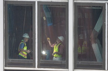 Varias personas inspeccionan una viga de soporte doblada en el interior del número 235 de la calle 42 Este, el miércoles 8 de julio de 2026, en Nueva York. (Foto AP/Yuki Iwamura)