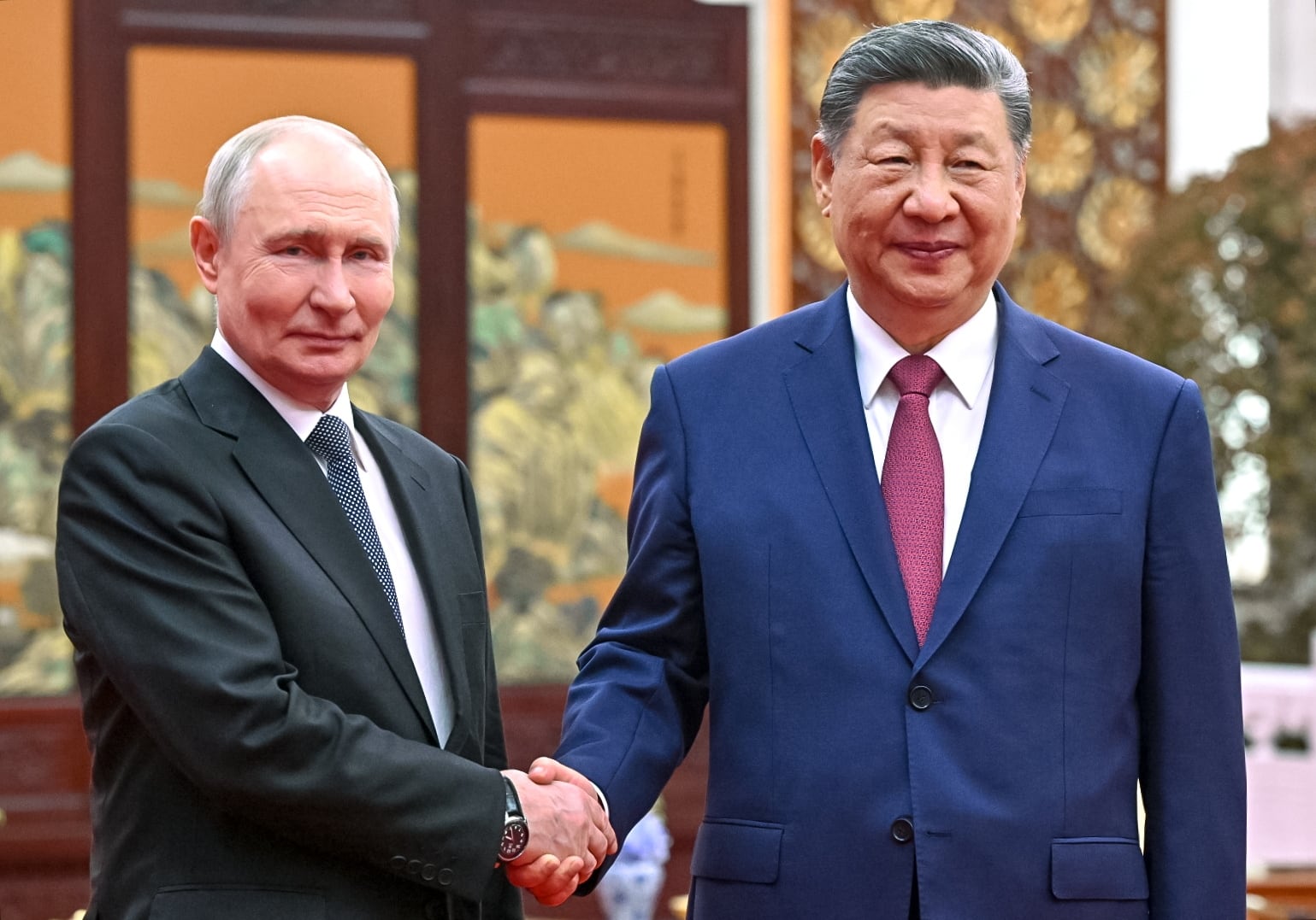 El presidente ruso Vladimir Putin (izquierda) estrecha la mano del presidente chino Xi Jinping durante una ceremonia del té celebrada en Beijing, China, el 20 de mayo de 2026 (EFE/EPA/KRISTINA SOLOVIEVA / KREMLIN)